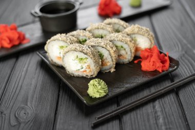 Siyah ahşap arka planda deniz mahsulleri olan sıcak tempura suşisi. Boşluğu kopyala