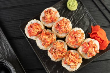 Siyah tahtada Amerikan usulü pişmiş suşi servis ediliyor. Üst görünüm