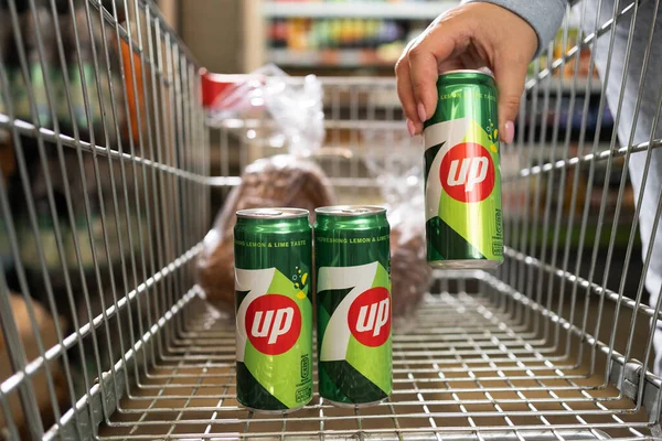 Stock image Odessa, Ukraine - 1 September 2023 : Shopper hand holding a can with 7up is American brand of lemon lime flavored non caffeinated soft drink. Copy space