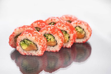 Sushi beyaz arkaplanda yansımalı yuvarlanıyor, metin için boşluk. Japon gıda konsepti