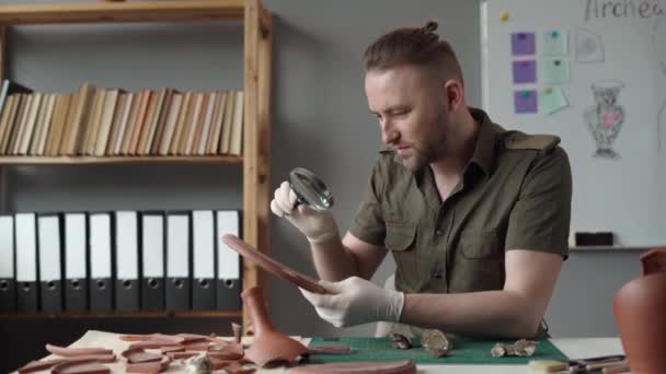 オフィスで働く考古学者で 古代の粘土工芸品を研究しています 考古学的な研究 コピースペース — ストック動画