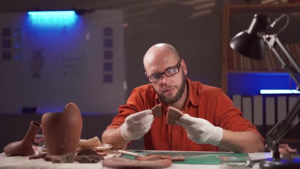 夜遅くにオフィスで働いている考古学者 古代文化の遺物について研究する 発掘と考古学のコンセプト — ストック動画