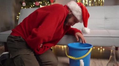 Evde bir Noel partisinden sonra akşamdan kalmayım. Mide bulantısı ve kusma çeken genç bir adam. Boşluğu kopyala