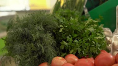 Maydanoz ve dereotunu marketten ya da süpermarket rafından almak. Markette dereotu seçen bir kadın. Boşluğu kopyala