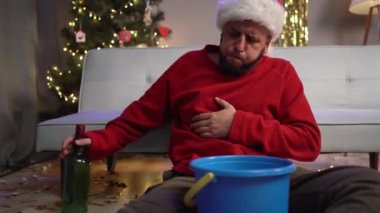 Parti sonrası kusmuk çeken Noel Baba şapkalı sarhoş adamın içki mahmurluğu konsepti var. Boşluğu kopyala