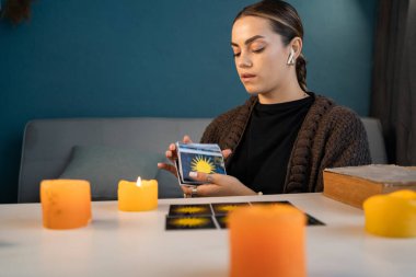 Evde tarot kartlarıyla fal baktırmak. Falcı geleceği görmek için bir deste kağıt karıştırıyor. Boşluğu kopyala