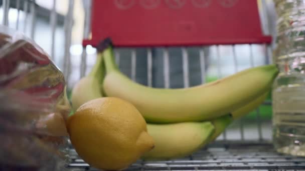 Egy Fiatal Gyümölcsöt Tesz Bevásárlókocsijába Bevásárlókocsiba Közelkép — Stock videók