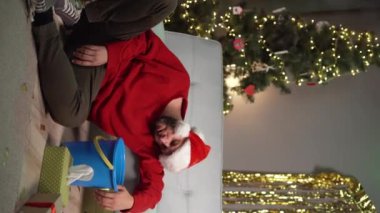 Evde bir Noel partisinden sonra akşamdan kalmayım. Mide bulantısı ve kusma çeken genç bir adam. Uzayı kopyala Dikey video