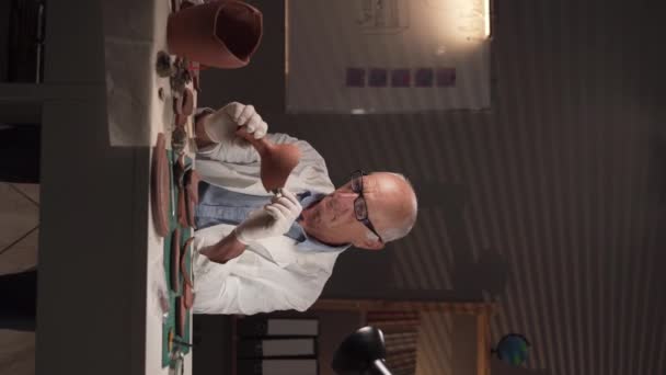 Geceleri Laboratuvarda Çalışan Yaşlı Erkek Arkeolog Masada Otururken Eski Bir — Stok video