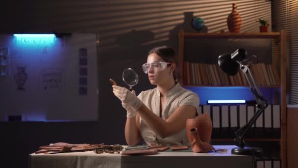 Kvinnlig Arkeolog Studerar Antik Artefakt Med Hjälp Ett Förstoringsglas Som — Stockvideo