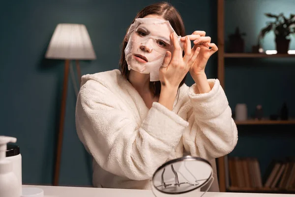 Beauty blogger applying a moisturizing face mask recording a video tutorial for her blog shares beauty secrets on social networks. Copy space