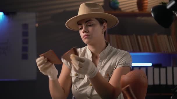 Archeologist Working Late Night Office Looking Artifact Parts Her Hands — Stock Video