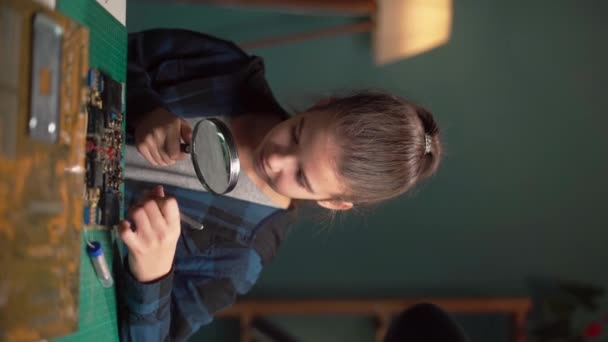 自宅でコンピュータ回路を修理する子供は ツイッターと壮大なガラスを使用しています 教育と科学のコンセプト バーティカルビデオ — ストック動画