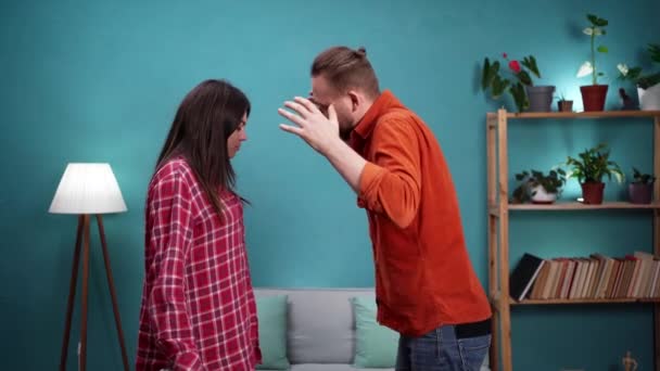ヤングは妻が浮気し 怒っている夫がリビングルームの女性に向かって叫ぶため 家で喧嘩をする夫婦と結婚した 関係問題コンセプト — ストック動画