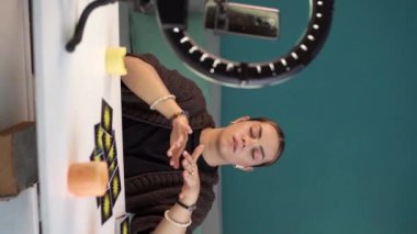Tarot okuyucu evde yanan mumların yanında tarot kartları okuyor. Akıllı telefon kullanarak falcı çevrimiçi. Okuma ve tahmin hakkında blog yazın. Dikey video