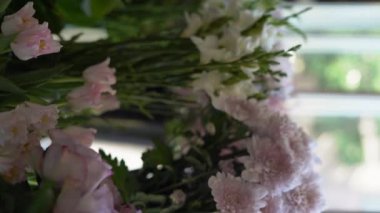 Çiçek açan güzel güller ve pembe renkli başka bir çiçek çiçekçi dükkanında vazoların içinde duruyor. Boşluğu kopyala