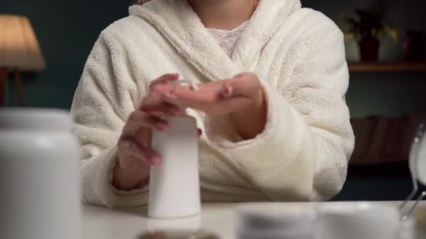 穿着浴衣的女人在手上涂保湿的护手霜 护肤化妆品 复制空间 — 图库视频影像