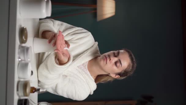 鏡の前に座っている保湿ハンドクリームを塗る女性 ハンドケアの概念 バーティカルビデオ — ストック動画