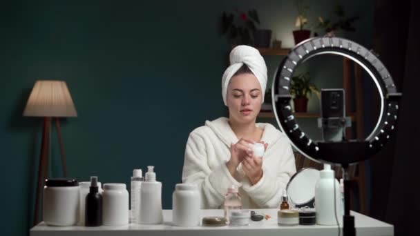 Vrouwelijke Schoonheid Blogger Dragen Badjas Tonen Gezicht Crème Opname Video — Stockvideo