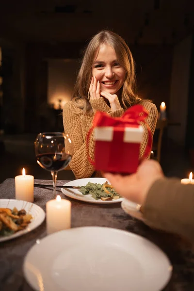 Romantic candlelight dinner for two, Valentine\'s Day date, man giving a gift to woman, romantic family relationship, Valentine\'s day celebration concept