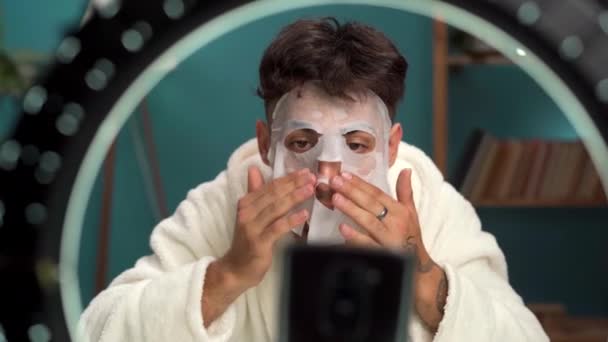Arabic Male Vlogger Applying Beauty Sheet Mask While Recording Video — Stock Video