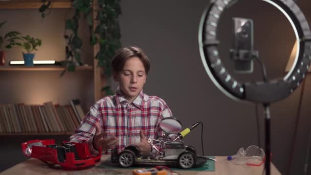 一位儿童博主记录了一个视频博客 内容是如何使用焊锡熨斗修理家中的玩具 复制空间 — 图库视频影像
