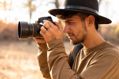 Sonbaharda dağlarda seyahat ederken doğa fotoğrafları çeken genç bir fotoğrafçının portresi. Boşluğu kopyala