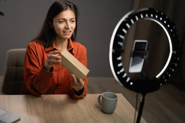 Milenyum blogcusu yeni teknoloji ürününü tanıtıyor, evdeki modern cihazların video incelemesini çekiyor. Kadın etkileyicisi teknoloji kanalı için içerik yaratıyor. Boşluğu kopyala