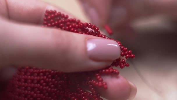 Detailní Záběr Ženských Rukou Tkajících Náramek Červených Malých Kuliček Zatímco — Stock video