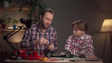 Milenyum babası oğluna uzaktan kumandalı araba lehimlemeyi ve bozuk oyuncakları tamir etmeyi öğretiyor. Boşluğu kopyala