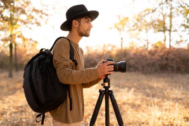 Tripod ve fotoğraf makinesi kullanan fotoğrafçı, gün batımının gün doğuşunu gösteren manzara. Boşluğu kopyala