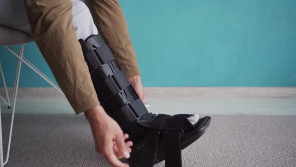 Verletzter Mann Entfernt Knöchelstütze Auf Stuhl Hause Nahaufnahme — Stockvideo