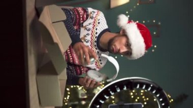 Genç Arap blogcu Noel 'de evdeki blog yazısında kulaklıkları inceliyor. Dikey video