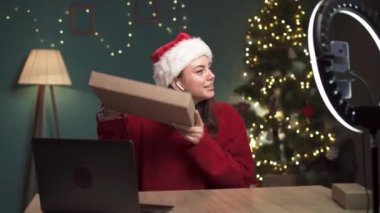 Sosyal medya etkileyicisi Noel için evde bir teknoloji ürününün kutusunu açan bir video kaydediyor. Blog yazarı takipçiler için bir ürünü inceliyor. Boşluğu kopyala