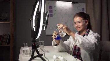 Öğrenci blogcu, takipçilerine laboratuarda kimya deneyi yaparken mavi sıvıyla test tüpü göstermiş. Boşluğu kopyala