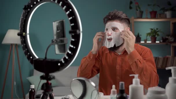 Blogueiro Beleza Masculino Vlogger Aplicando Máscara Folha Beleza Durante Gravação — Vídeo de Stock