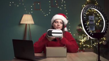 Sosyal medya teknolojisi etkileyicisi Noel Baba şapkası takıp Noel 'de evde boks videosu açıyor. Boşluğu kopyala
