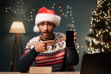 Vlogger kameraya sunum yaparken cep telefonunun paketleme görüntülerini açıyor. Noel Baba şapkasındaki sosyal medya etkileyicisi Noel 'de akıllı telefonu açıyor. Boşluğu kopyala