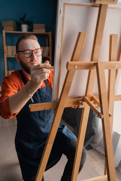 Мужчина рисует на холсте в домашней студии. Концепция хобби и отдыха. Копирование пространства