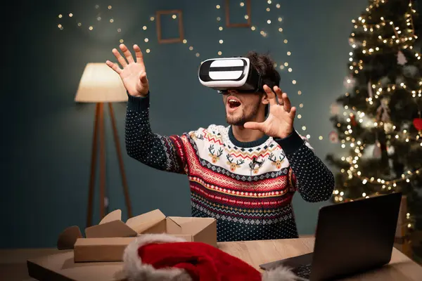 blogging, technology and people - happy guy blogger in Santa hat with ring light and smartphone doing VR glasses test live. concept of advertising products to bloggers on Christmas Eve. Copy space