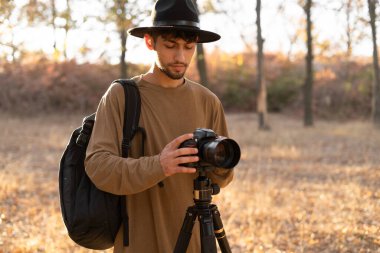 Profesyonel fotoğrafçı doğayı sabah ya da gün batımında kamera ve tripodla fotoğraflıyor. Boşluğu kopyala