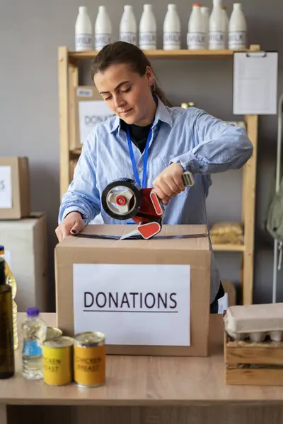 Kadınlar, fakir insanlar veya mülteciler için bağışlarla dolu bir kutuyu kasede çekmeye gönüllü oluyorlar. hayır, bağış ve gönüllülük konsepti