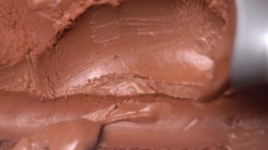 Paslanmaz çelikten dondurma kepçesiyle en tepedeki adam çikolatalı dondurma topluyor. Boşluğu kopyala