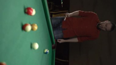 Çekici adam Amerikan bilardosu oynuyor. Bilardo sporu konsepti. Dikey video