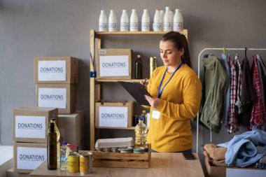 Dağıtım ya da mülteci yardım merkezinde pano kutu yiyecek taşıyan kadın gönüllü. Sadaka, bağış ve gönüllülük konsepti