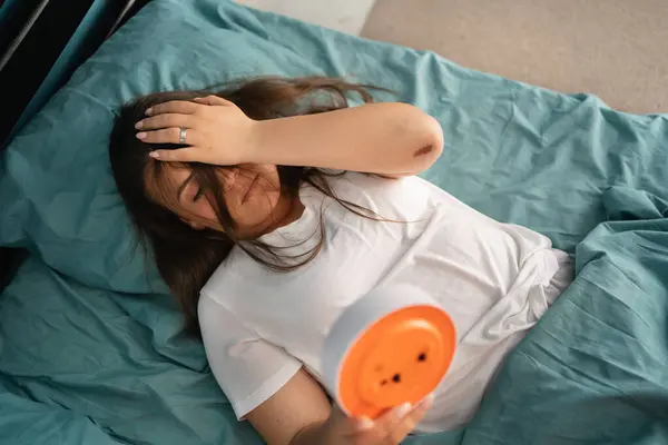 불행한 여자가 시계와 침대에 직장에서 아침에 일어나지 않습니다 잠이없는 오버헤드 스톡 이미지