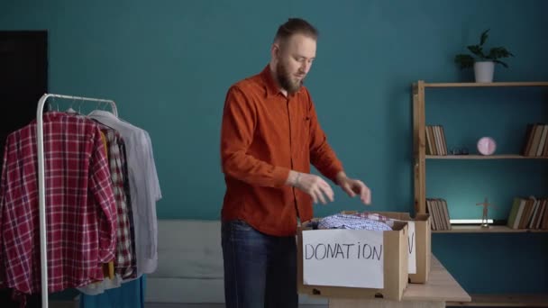 貧しい人々 人道援助のための衣服が付いている寄付箱を詰める男 コピースペース — ストック動画