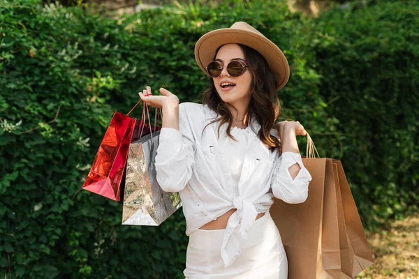 Female shopping. Happy young woman wear eyeglasses with shopping bags enjoying in shopping. Consumerism, shopping and lifestyle concept