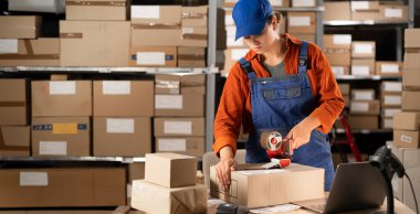 Depo kadın çalışanı büyük bir depoda sevkiyat hazırlıyor. Boşluğu kopyala