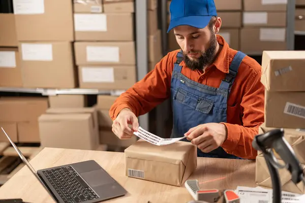 Çevrimiçi mağaza sahibi paket kutusuna barkod etiketi yapıştırıyor ve bir depoya nakliye siparişi hazırlıyor. Boşluğu kopyala